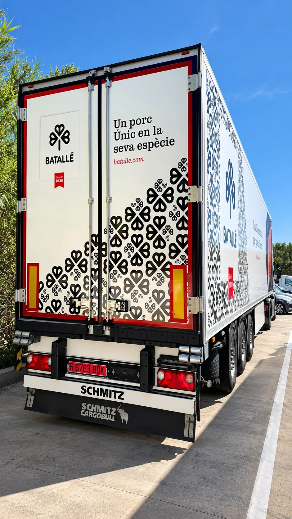 Part posterior d’un camió de Batallé amb logotip, missatge i patró gràfic